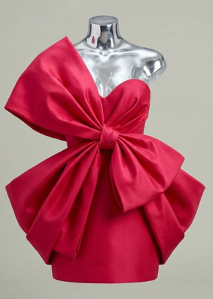 Architectural red mini dress with oversized sculptural bow front view.